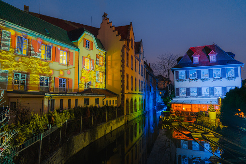Christmas lights illuminating the streets of Colmar at night. Reflection on river