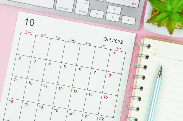 istock October 2022 calendar sheet with keyboard computer on pink background. 1361535960