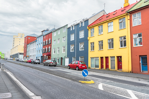 Row of colourful apartment buildings along a street on a cloudy day. Reykjavik, Iceland.