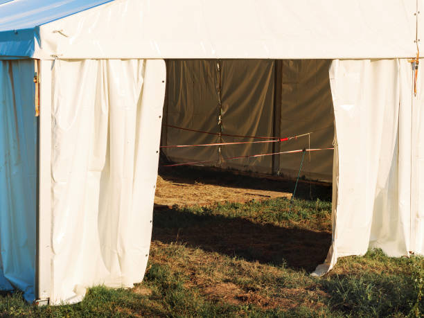 istock White large canvas tent lit by the sun stands on the grass with ropes stretched inside 1361546701