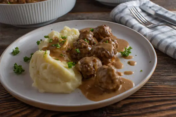 Traditional fresh and homemade cooked köttbular, delicious meatballs from sweden. Served with mashed potatoes and brown sauce on a plate