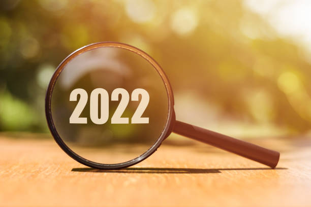 istock 2022 text in magnifying glass on wooden surface over blur green tree in park 1361550941