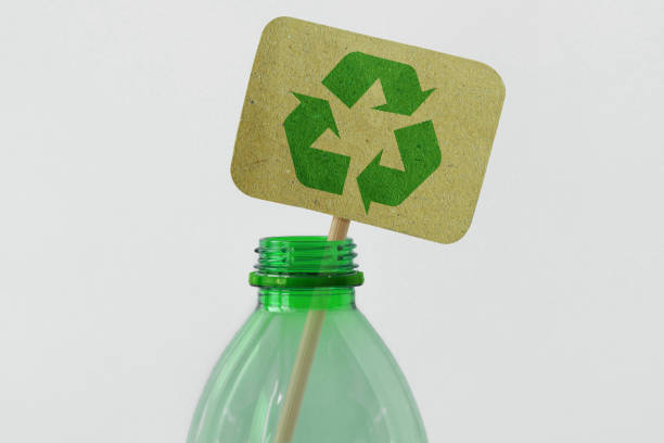 Plastic bottle with recycling symbol on recycled paper sign - Ecology concept stock photo