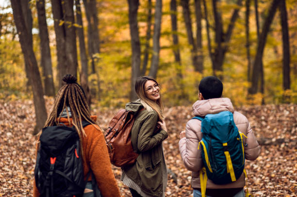 istock Three female friends having fun and enjoying hiking in forest. 1361553886