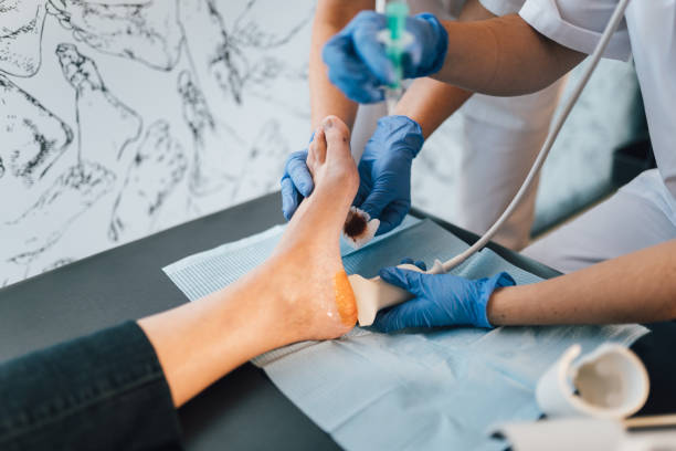 chiropodist doing an ultrasound test to patient's foot. - podiatrist podiatry pedicure chiropodist imagens e fotografias de stock