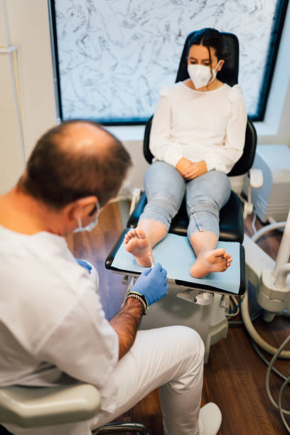 chiropodist exploring a patient with diabetic foot in the medical center with face mask during covid coronavirus pandemic. - podiatrist podiatry pedicure chiropodist imagens e fotografias de stock