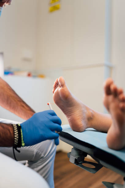 chiropodist exploring a patient with diabetic foot in the medical center with face mask during covid coronavirus pandemic. - podiatrist podiatry pedicure chiropodist imagens e fotografias de stock