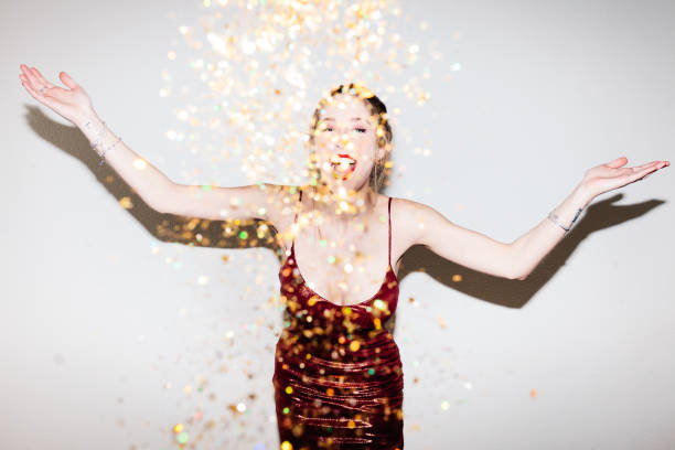 istock Young woman celebrating her 21st birthday illuminated with hard flash light. 1361559439