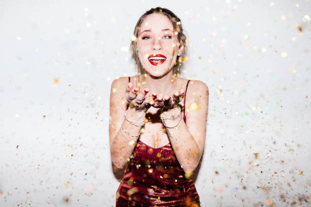 istock Young woman celebrating her 21st birthday illuminated with hard flash light. 1361559445