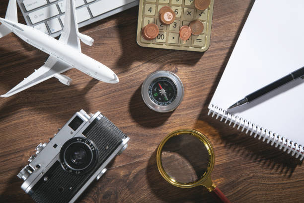 istock Calculator, coins, retro camera, airplane on the wooden background. 1361573408