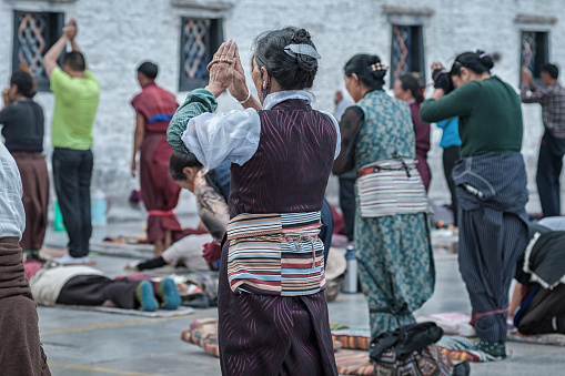 Pilgrims praying  worshipping in front of Jokhang temple. The Buddhist Temple in Barkhor Square is considered the most sacred and important temple in Tibet.