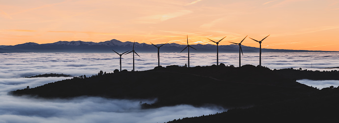 Wind farm at misty sunset, Navarre (Spain). Renewable energy concept. Panoramic view XXXL