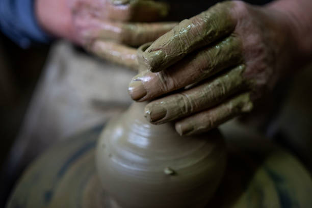 Cropped hands of potter making pot