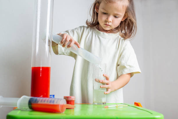 istock Child pours baking soda into a test tube with vinegar while making a chemistry experience at home. Homeschooling and distance education 1361578494