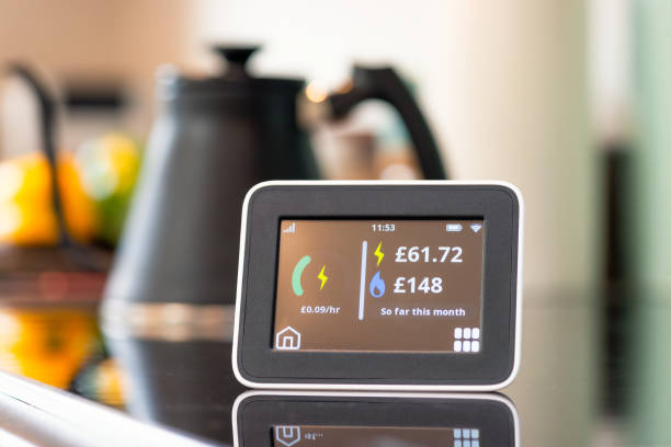 UK Domestic Smart Meter display Close-up of the screen of a smart meter display in a kitchen, showing the monthly cost of electricity and gas so far. energy crisis photos stock pictures, royalty-free photos & images