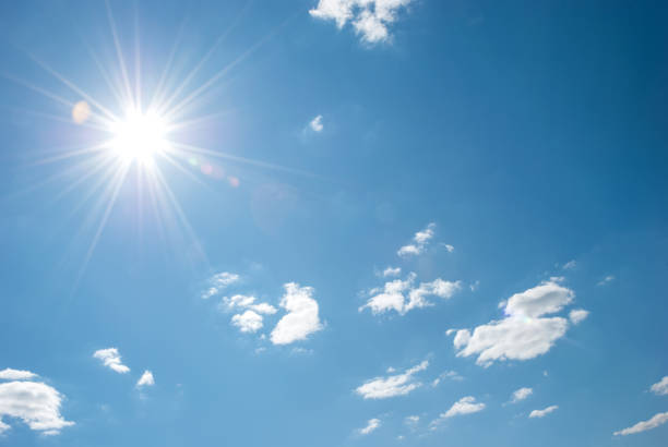 istock Beautiful, blue summer sky with fluffy clouds and bright sun as a background 1361583486
