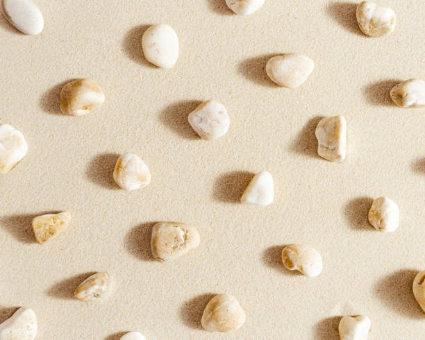 istock Aesthetic minimal pattern with set of pebble stones on fine sand background. Top view on natural stone neutral beige color. Summer concept 1361583717