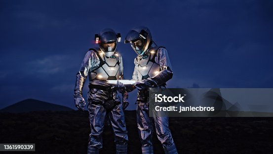istock Selfie out of this world. Astronauts in futuristic suits taking photo and setting the light 1361590339