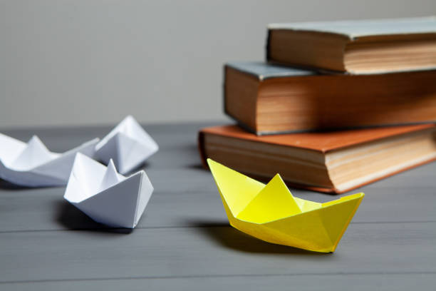 istock white ships go for yellow next to books 1361590343