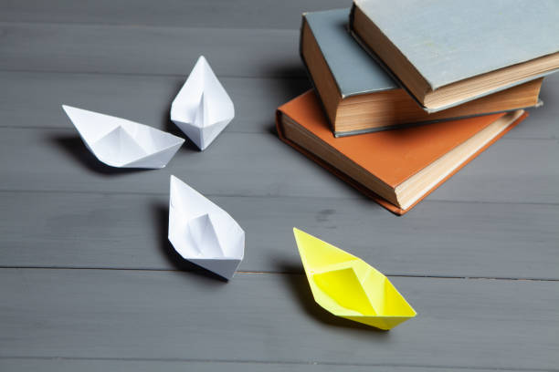 istock white ships go for yellow next to books 1361590346