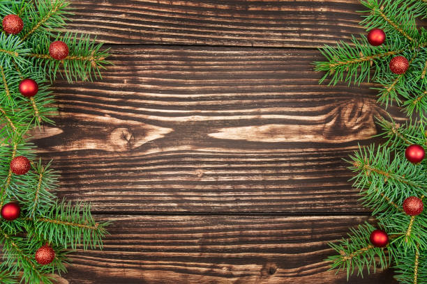 istock Fir tree branches decorated with red ornaments on wooden background 1361590659