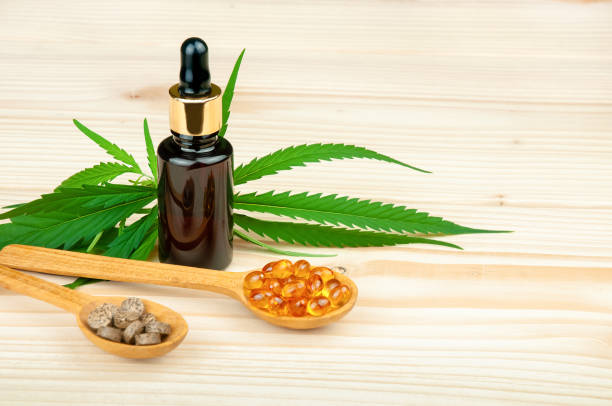 cbd oil bottle, medicinal cannabis leaves and cbd capsules and tabletes on wooden table - narcotic medicine pill insomnia imagens e fotografias de stock