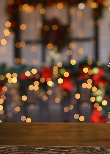 Christmas background. Empty wooden board on background of blurred christmas house outdoors and New Year's golden bokeh.Ready for product montage. Banner. Copy space