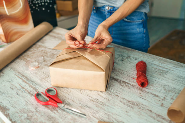 istock Young woman wrapping a gift 1361594675