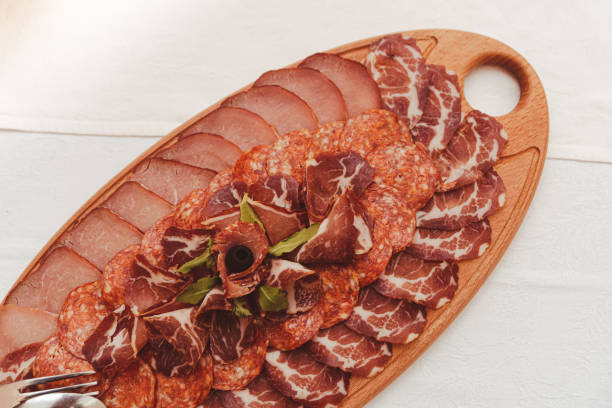 istock Smoked meat cut thin and served on a wooden plate 1361594920