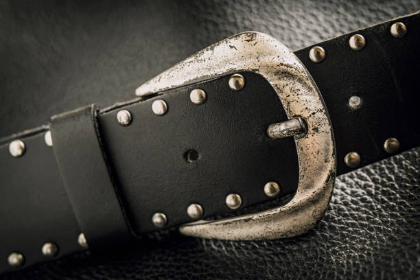 istock Old leather belt with metal buckle and rivets on dark background 1361596202