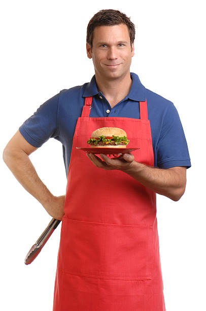 istock Man in Apron Holding Hamburger Isolated on White Background 136159848