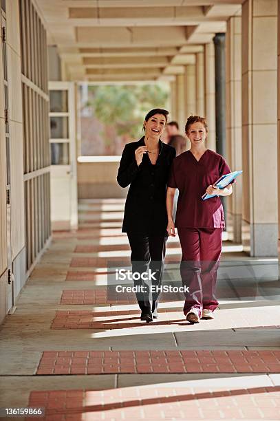 Feminino Médico E Enfermeira A Andar Ao Longo Corredor - Fotografias de stock e mais imagens de Ao Ar Livre