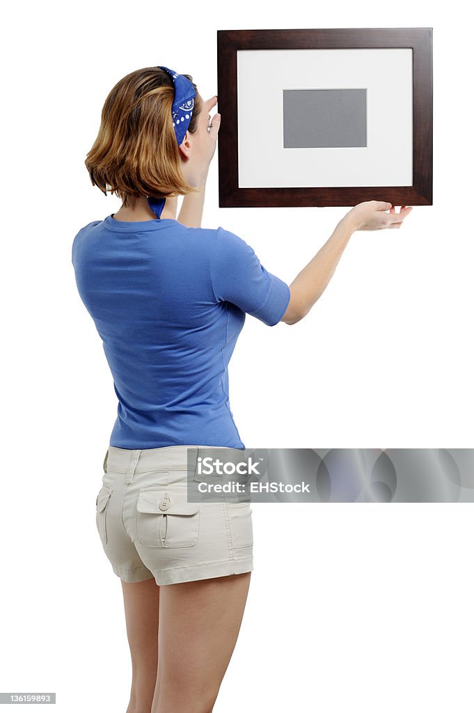 Junge Frau hängen Bilderrahmen isoliert auf weißem Hintergrund - Lizenzfrei Bilderrahmen Stock-Foto