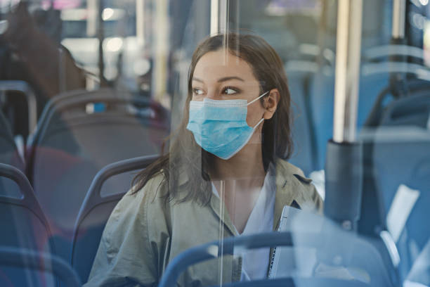 istock Woman with a protective face mask in a bus 1361604288