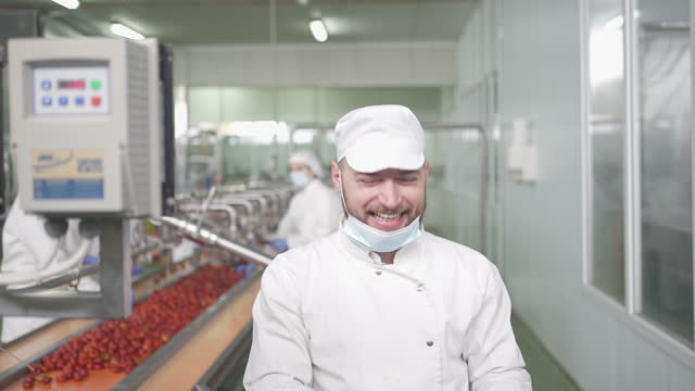 Smiling Male Checking Stuffed Peppers On Production Line In Factory