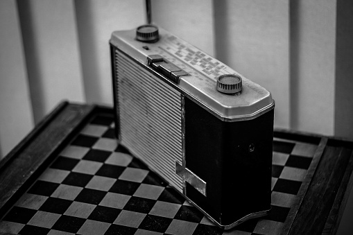 Old radio set on a checkerboard, a vintage era
