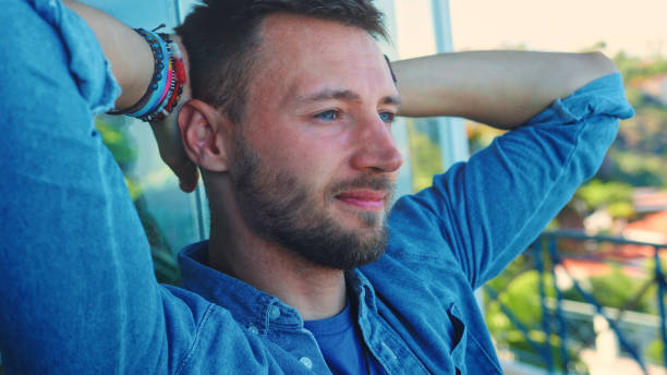 istock Man admiring a view from a patio. Leaning on panoramic windows 1361605727