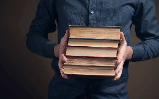 istock man holding books in his hands 1361605863