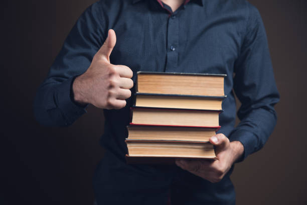 istock man holding books and showing thumb up 1361605865