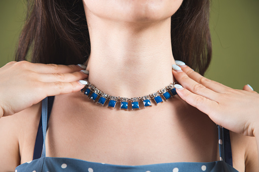 young woman shows a necklace on her neck