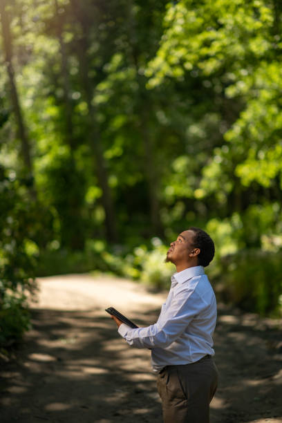 istock Young Businessman Environmentalist with digital tablet standing outdoors waist up copy space 1361606654