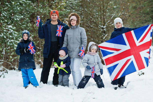 famiglia con quattro bambini che tengono la bandiera della gran bretagna sul paesaggio invernale. - 12 23 mesi foto e immagini stock