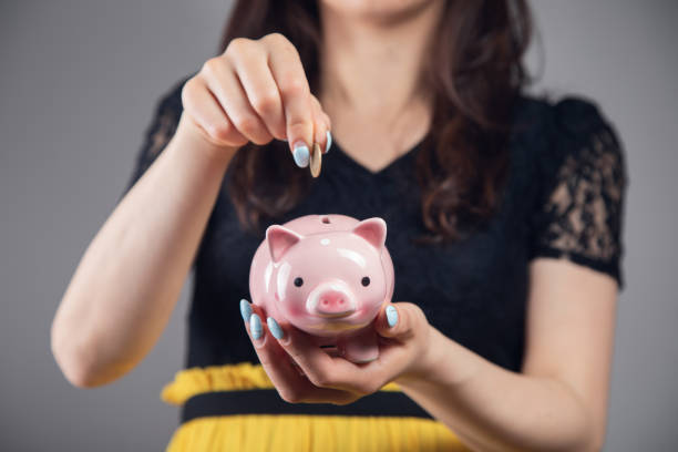 istock throws a coin into a piggy bank 1361609068