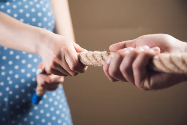 istock a man and a woman pulling the rope 1361609820