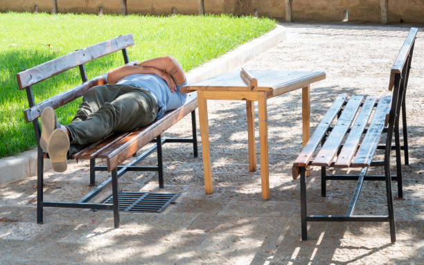 Homeless man sleeping on park bench in Tokyo
