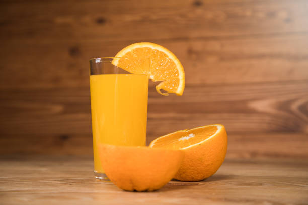 istock on a wooden table an orange and a glass with a drink 1361611285