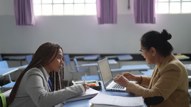 Teacher giving support or advice to student in the classroom