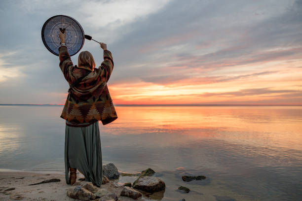 giovane sciamana etnica matura femmina cammina e suona la musica meditativa dei tamburi - ceremony foto e immagini stock