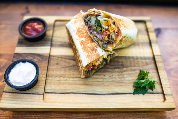 istock A burrito with dips cut in half on a wooden board 1361612467