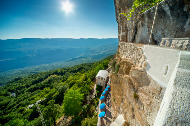 mirante do mosteiro de ostrog, com vista para as planícies de bjelopavlici em um dia de verão, montenegro. - ostrog - fotografias e filmes do acervo